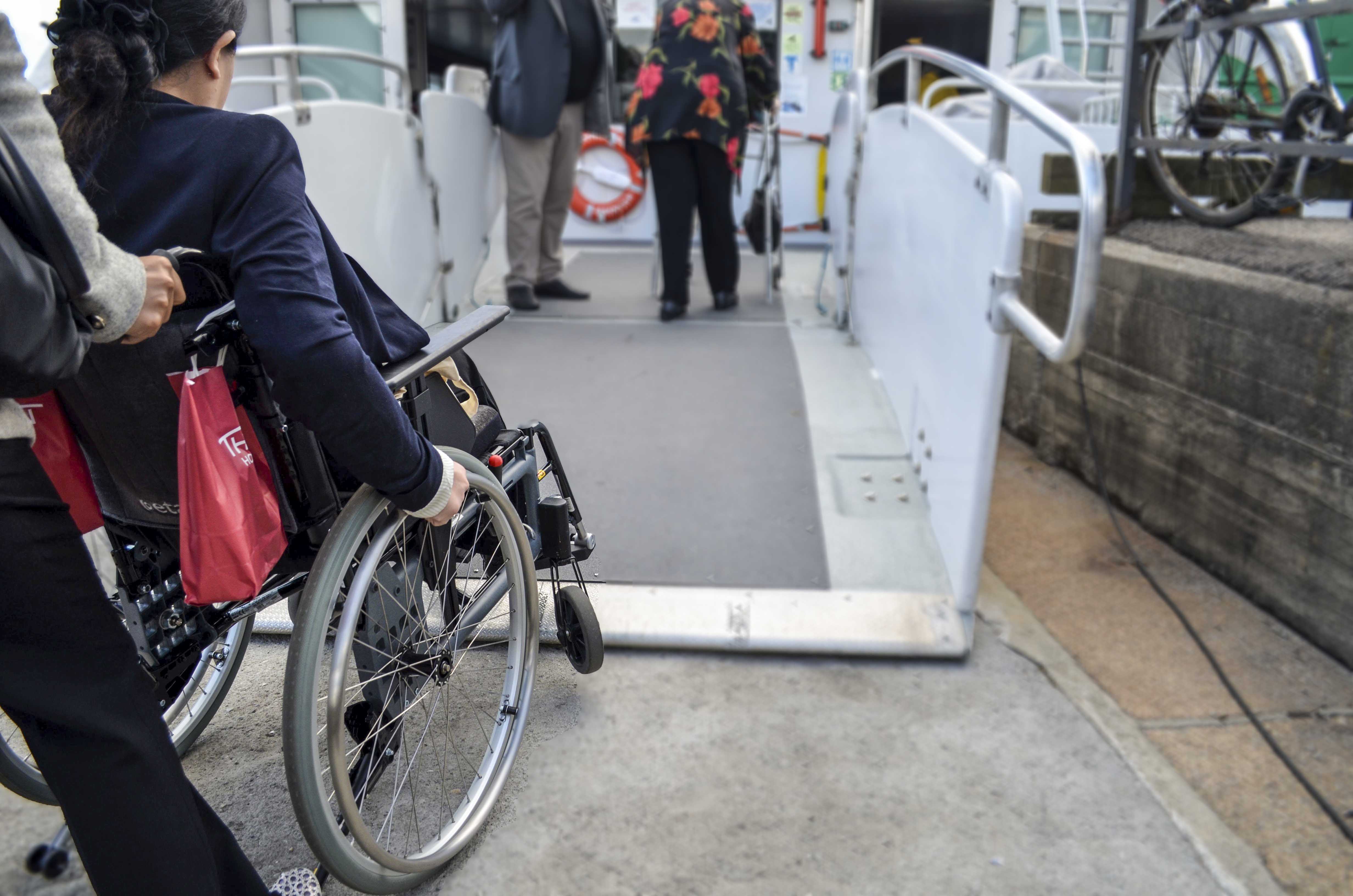 Woman in a wheelchair is at the ferry gate