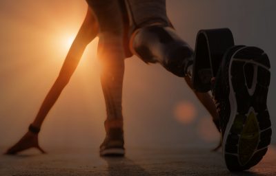 Back view of disabled athlete woman with prosthetic leg