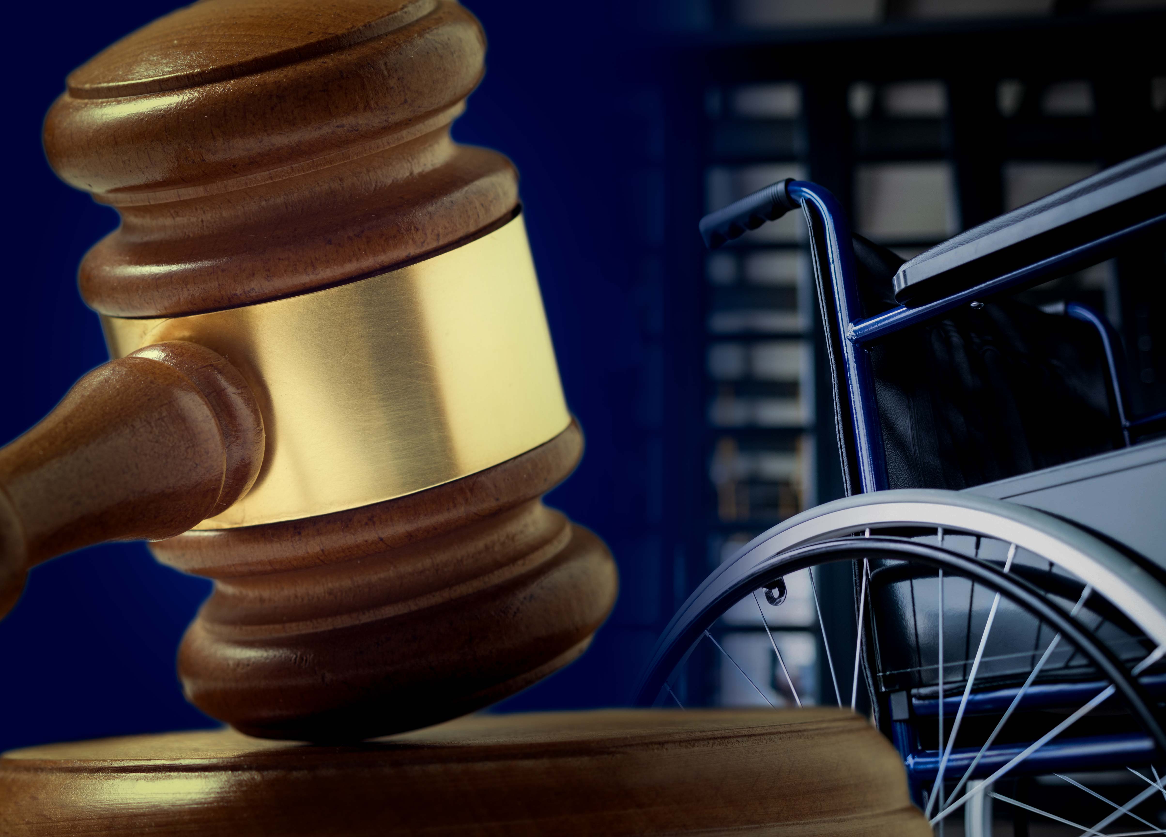 Wooden gavel with wheelchair in background