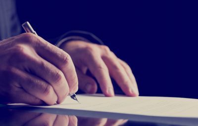 Close up Human Hand Signing on Formal Paper