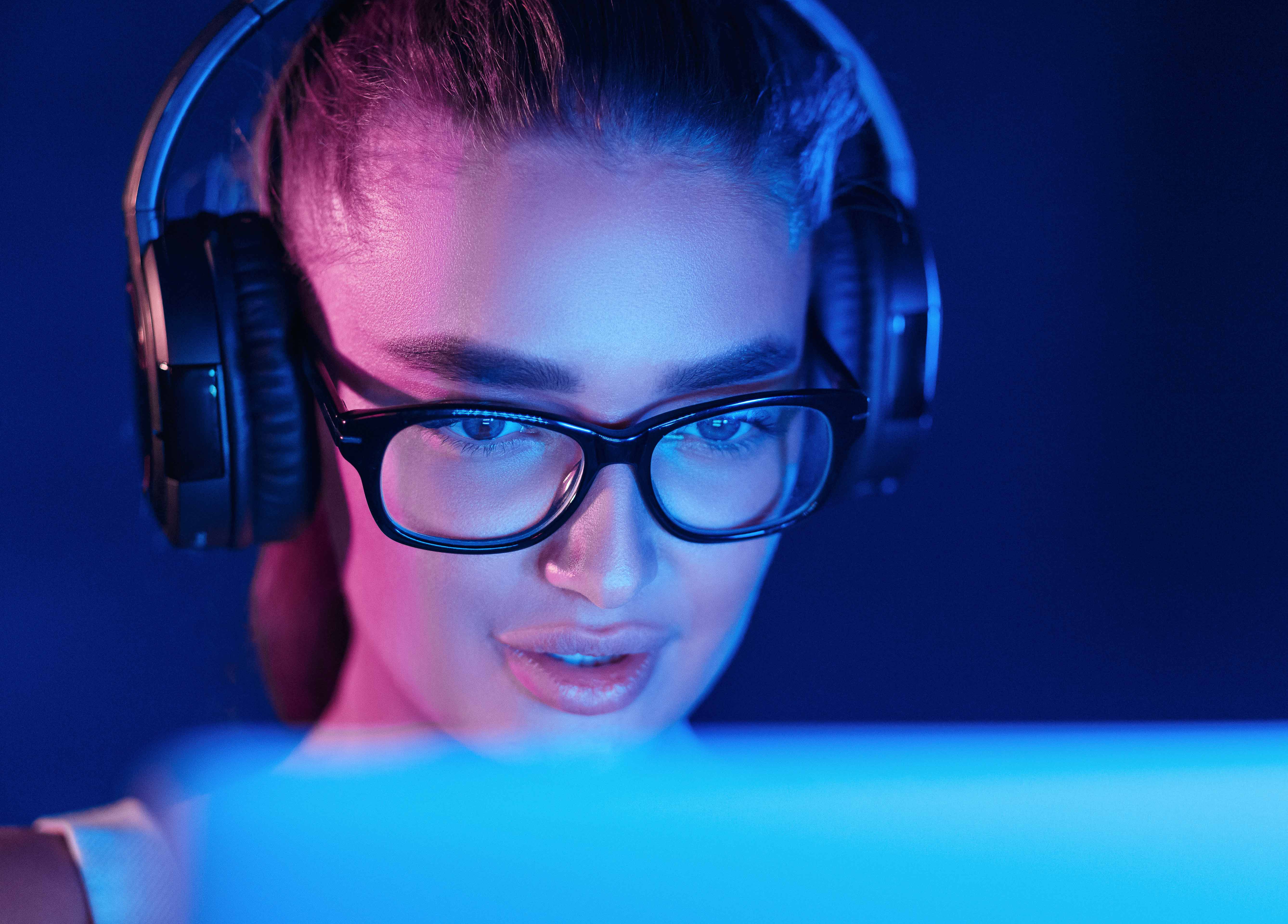 Female pro gamer playing video game, wearing headset