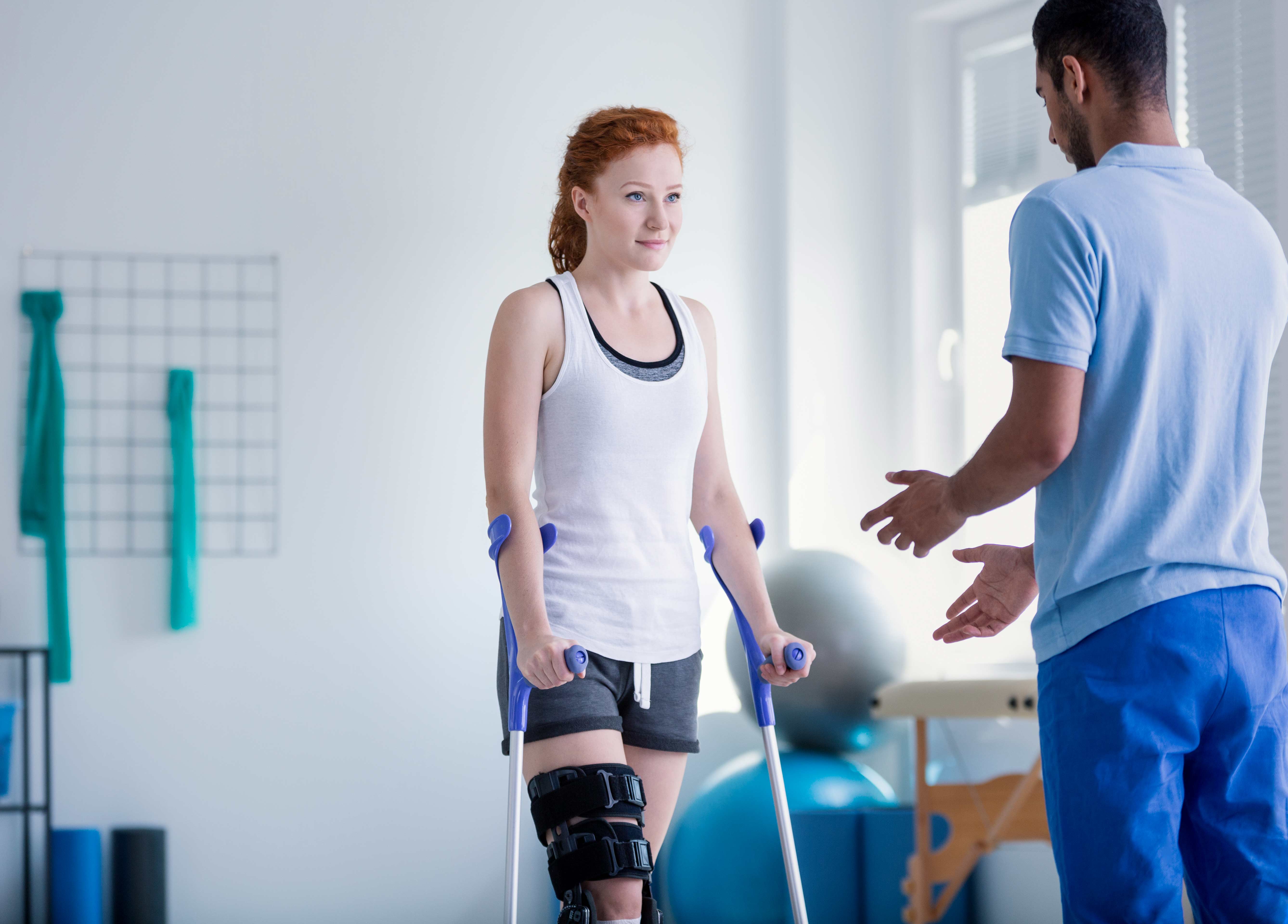 Woman with crutches during rehabilitation with physio