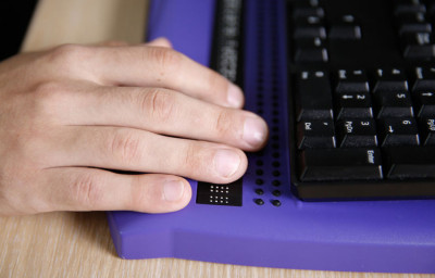 Blind person using computer with braille computer display