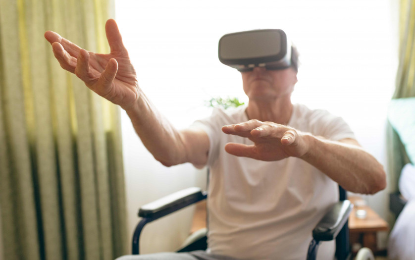 Disabled man using virtual reality headset in wheelchair