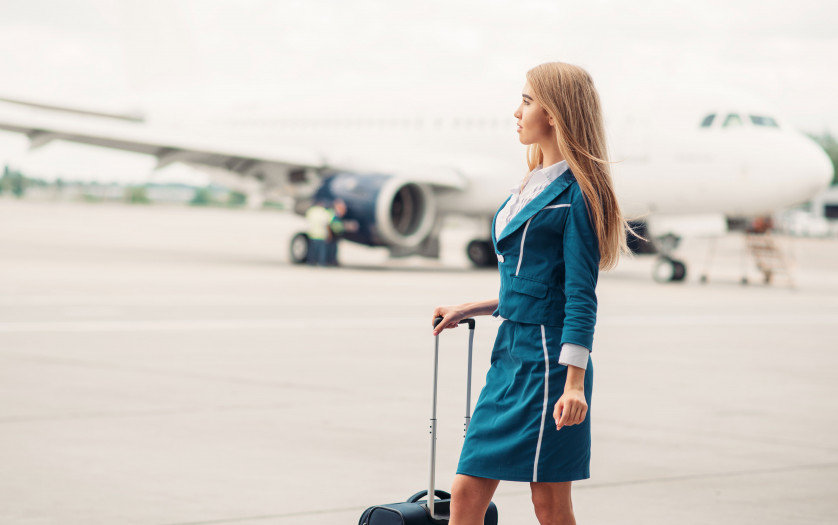 stewardess with suitcase on aircraft parking