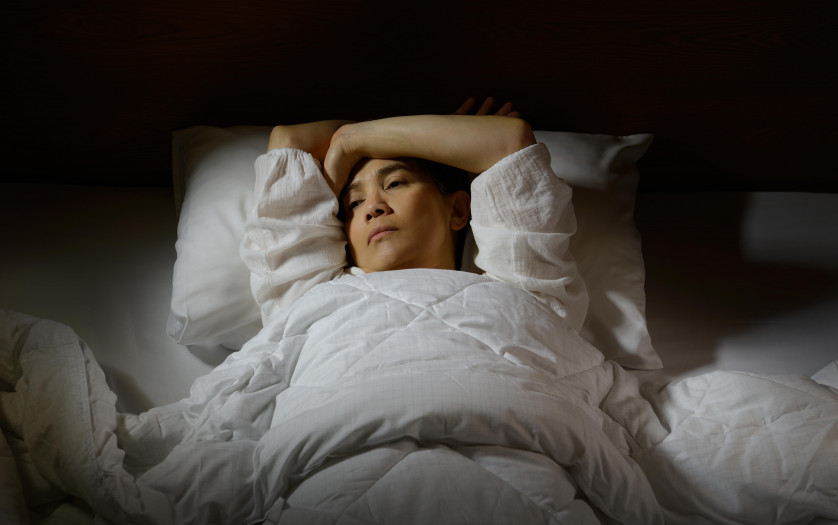 Woman with lying in bed with open eyes