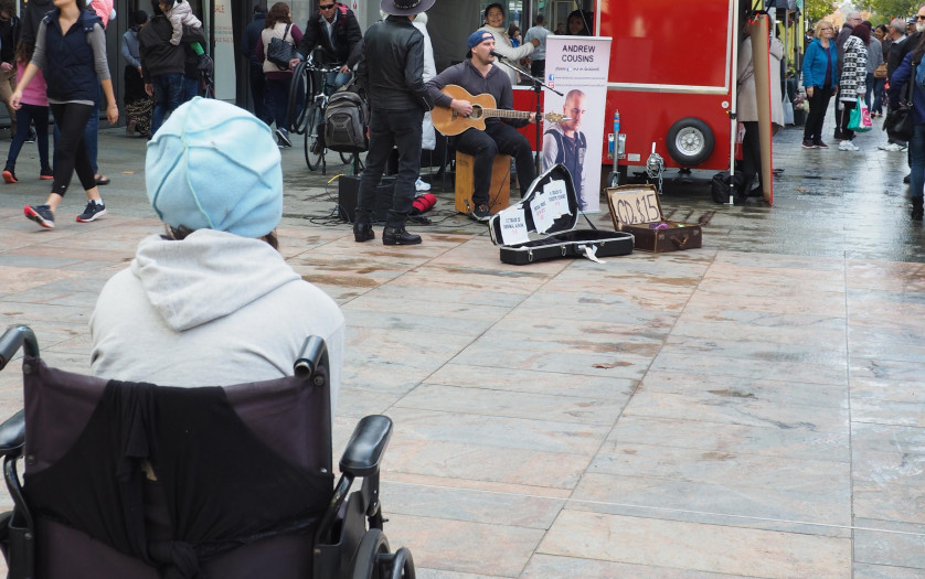 Wheelchair user listening street music
