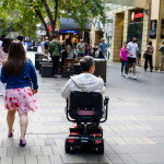 A disabled man on mobility scooter and other people at Sydney CBD