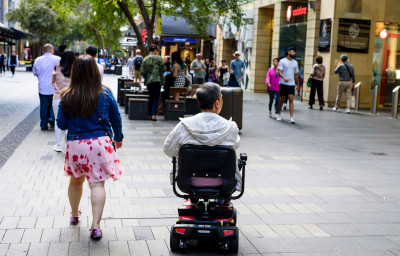 A disabled man on mobility scooter and other people at Sydney CBD