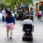 A disabled man on mobility scooter and other people at Sydney CBD