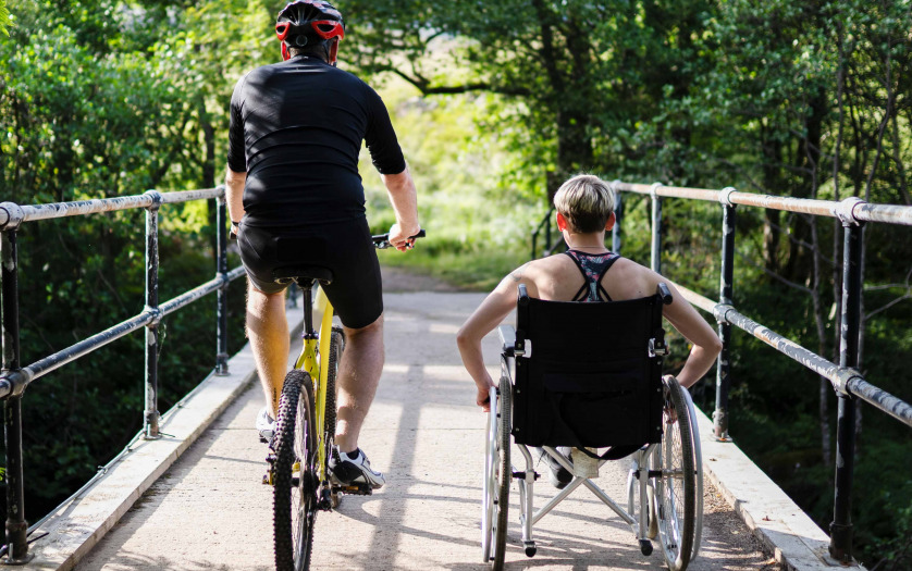 Couple together on a bicycle and in a wheelchair
