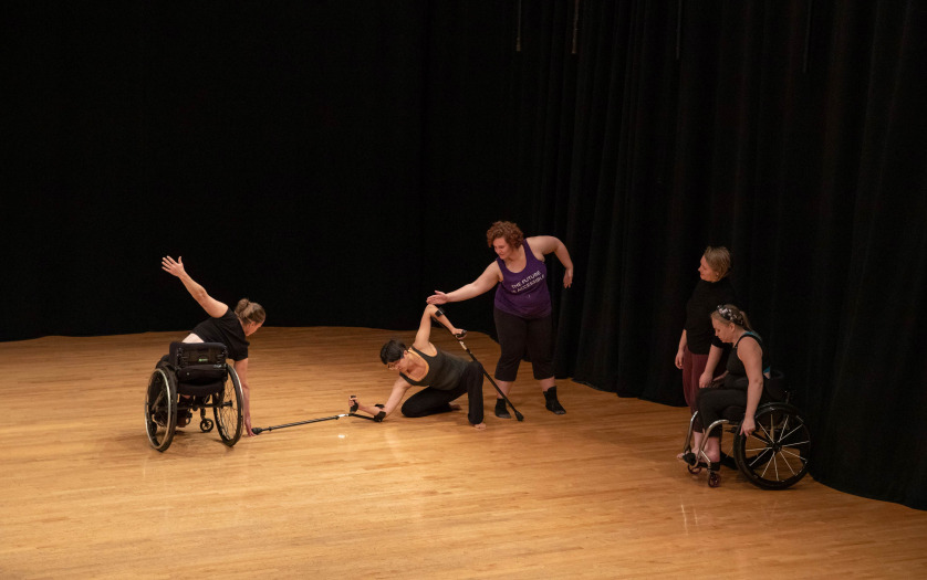 Instructors with dancers in wheelchair performing dance at the public showcase.