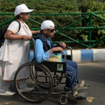 woman helps a disabled person in wheelchair in India