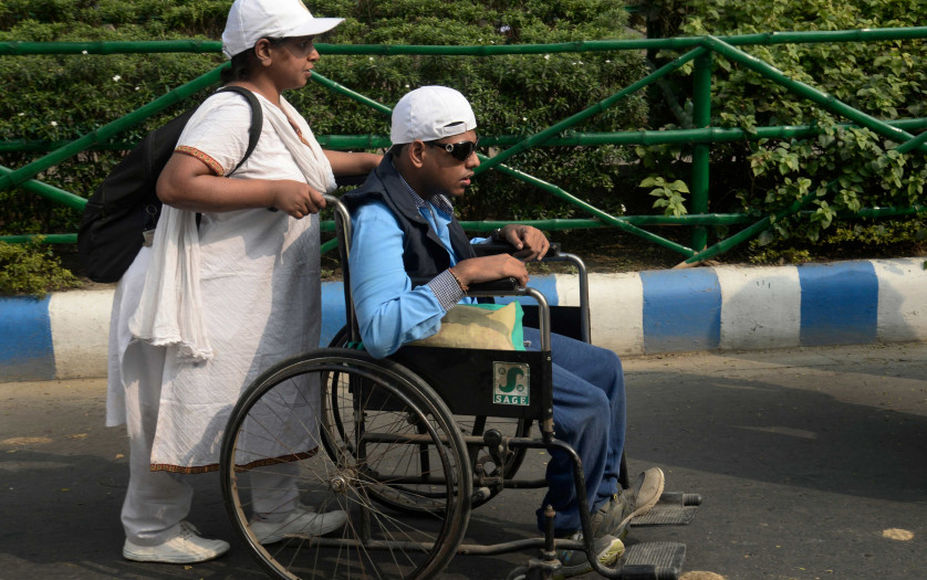 woman helps a disabled person in wheelchair in India