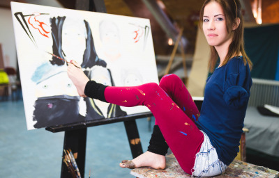 young artist with disability painting incredible scenes in attic by holding paintbrush in her toes