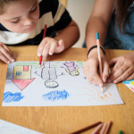 Sister and brother with disability drawing
