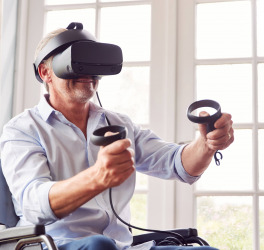 a man in wheelchair doing exercise using VR headset
