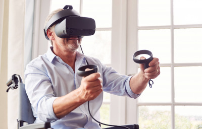 a man in wheelchair doing exercise using VR headset