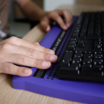 Blind person using computer with braille computer display and a computer keyboard