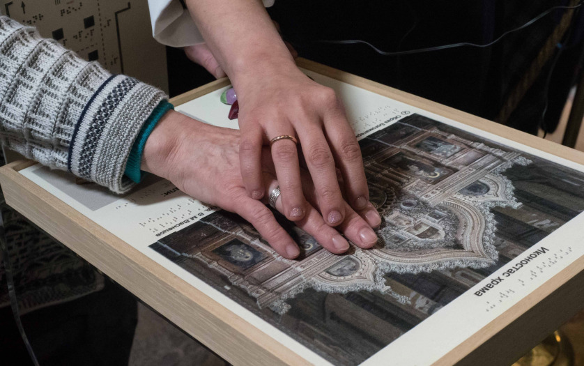 blind woman touches hands tactile paintings in the museum