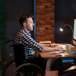 man in wheelchair working in office