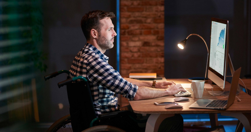 man in wheelchair working in office