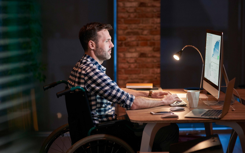 man in wheelchair working in office