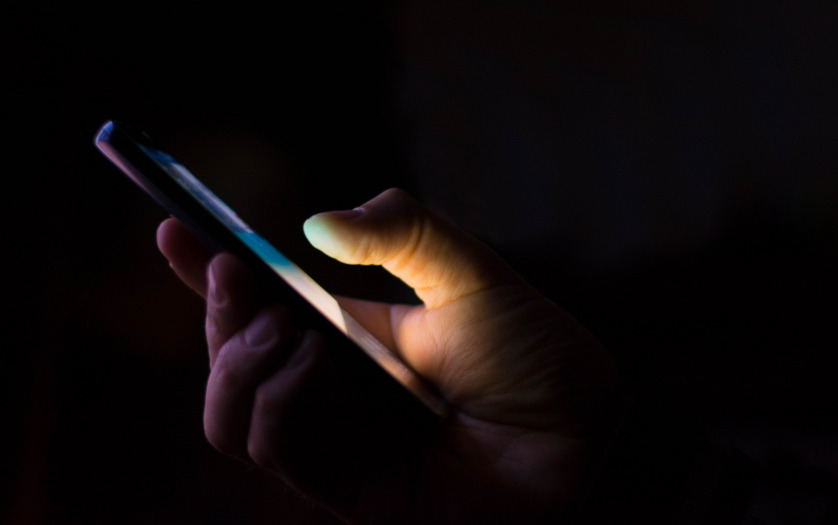 person texting in dark