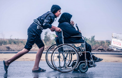 son pushing mother in wheelchair