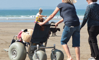 Woman pushing beach wheelchair