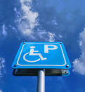 Low angle view of blue handicapped parking sign against blue cloudy sky at day time