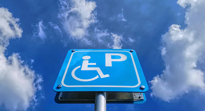 Low angle view of blue handicapped parking sign against blue cloudy sky at day time