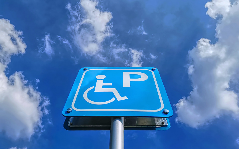 Low angle view of blue handicapped parking sign against blue cloudy sky at day time