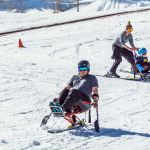 disabled person riding a mono ski Adaptive Snow Sports