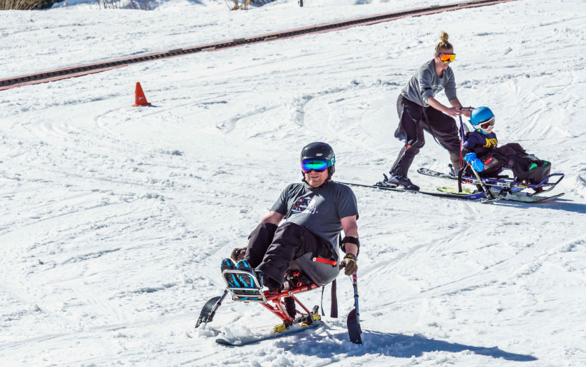 disabled person riding a mono ski Adaptive Snow Sports