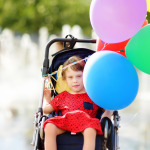 Cute little girl with cerebral palsy in a wheelchair celebrate birthday