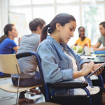 woman in wheelchair working on tablet