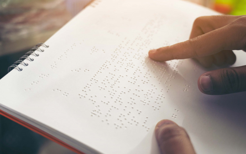 Close-up of fingers reading braille, Hand of a blind person reading some braille text of a braille book.