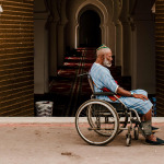 Muslim man in wheelchair at the door of the mosque.
