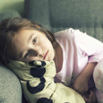 Child in a night suit tired, lay down on the couch