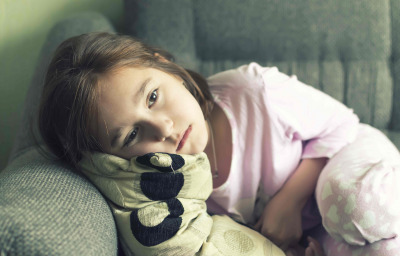 Child in a night suit tired, lay down on the couch