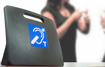 Two deaf people using American Sign Language next to a Tele Coil Magnetic Loop with T-switch with induction system for hearing aids