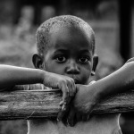 African boy leaning on a tree