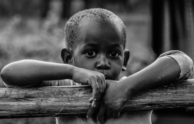 African boy leaning on a tree