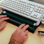 Blind person using computer with braille computer display