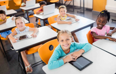Aerial view of pupils working with tablets