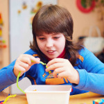 portrait of happy kid with disability develops fine motor skills