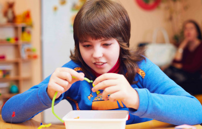 portrait of happy kid with disability develops fine motor skills