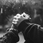Happy couple holding hands by the window