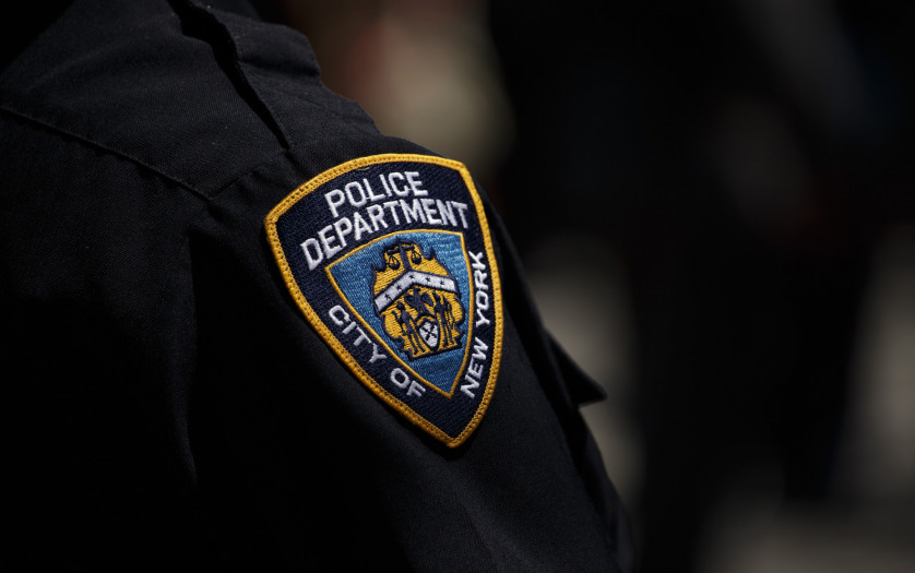 New York City Police Department (NYPD) badge on police officer's arm.